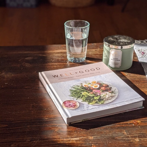 cookbook, water glass and candle in sun